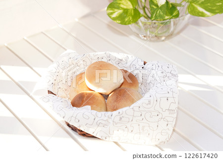 Fresh bread buns in basket on table. Breakfast buns. 122617420