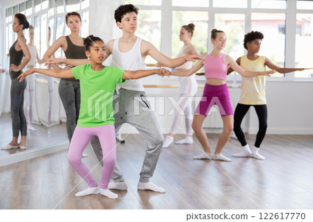 Teenage girl and boy practicing plie position of ballet in dance studio 122617770