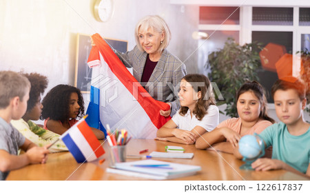 Female teacher showing dutch flag to kids in geography class 122617837