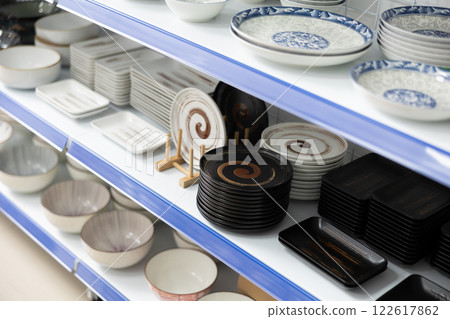 In cookware department, plates of various shapes and sizes, with different patterns, are on shelves In cookware department, plates of various shapes and sizes, with different patterns, are on shelves 122617862