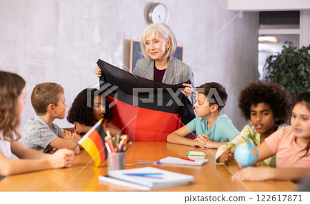 Friendly female teacher tells pupils the history of Germany 122617871