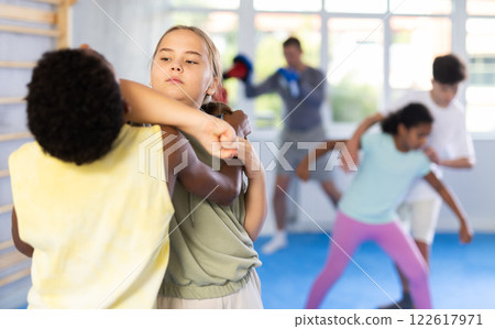 Preteen children pairs learning strength self-defense in gym 122617971
