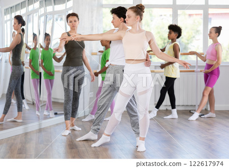 Teenage girl practicing ballet positions in pair with boy in dance studio Teenage girl practicing ballet positions in pair with boy in dance studio 122617974