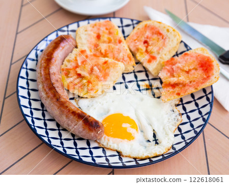 Fried eggs with sausage and baguette slices Fried eggs with sausage and baguette slices 122618061