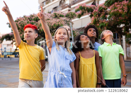 Inquisitive carefree tweens looking up at sky and pointing at something Inquisitive carefree tweens looking up at sky and pointing at something 122618062