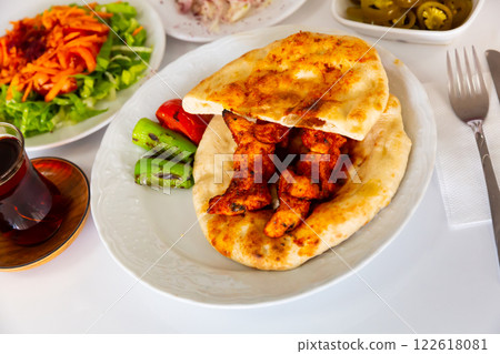 Turkish chicken shish kebab on pita bread with vegetables Turkish chicken shish kebab on pita bread with vegetables 122618081