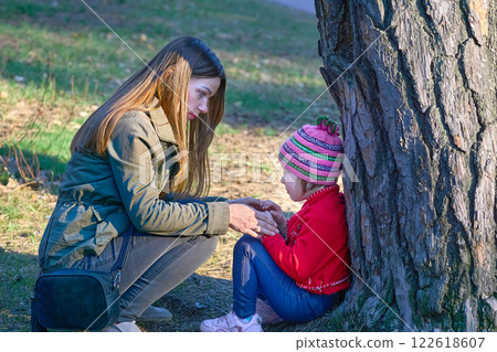 Cute mommy brings up scolds the child in the spring park on the playground 122618607