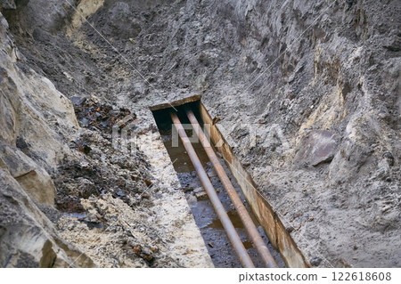 Dug hole with plastic metal water sewer pipes for repair Dug hole with plastic metal water sewer pipes for repair 122618608
