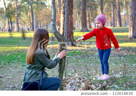 Cute mommy brings up scolds the child in the spring park on the playground 122618639
