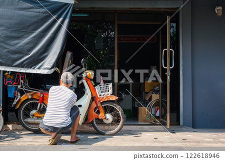 Checking classic motorcycle for repair at garage 122618946