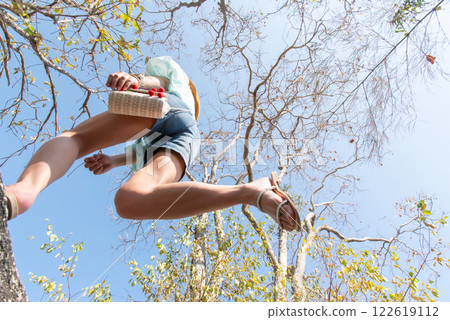 Woman jumping or crossing step over in forest 122619112