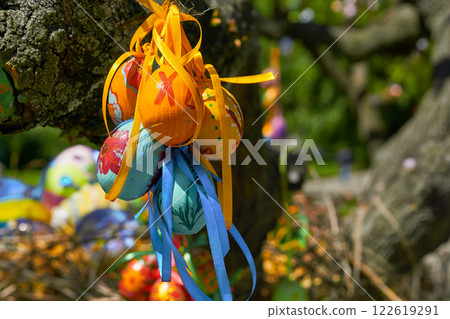 Bunch of colorful painted Easter eggs on green spring tree 122619291