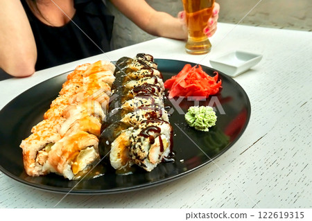 Delicious set of fresh sushi, pickled ginger in cafe Delicious set of fresh sushi, pickled ginger in cafe 122619315