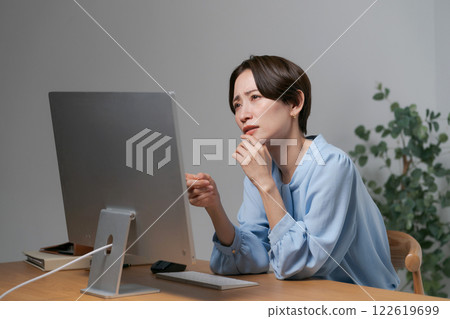 A woman troubled by looking at the screen of a personal computer 122619699