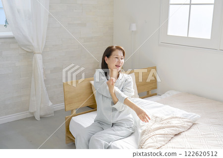 Middle-aged woman stretching arms waking up 122620512