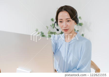 Middle-aged woman having an online meeting while teleworking Middle-aged woman having an online meeting while teleworking 122621335