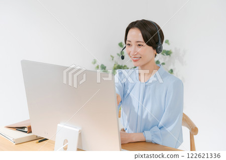 Middle-aged woman having an online meeting while teleworking 122621336