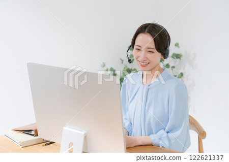 Middle-aged woman having an online meeting while teleworking Middle-aged woman having an online meeting while teleworking 122621337