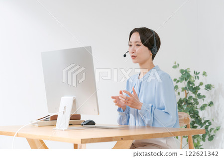 Middle-aged woman having an online meeting while teleworking 122621342