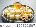 different types of cheese cubes on plate, serving with honey and nuts 122621607