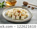 cheese on plate, restaurant serving with honey, nuts and greenery, minimalistic  122621610