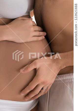 Shirtless man kissing pregnant woman Shirtless man kissing pregnant woman 122621888