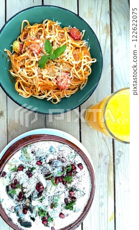Pasta adorned with fresh herbs from bioFarm, complemented by creamy salad. Pasta celebrates fresh herbs and ingredients from bioFarm. Wholesome dining concept. Pasta adorned with fresh herbs from bioFarm, complemented by creamy salad. Pasta celebrates fresh herbs and ingredients from bioFarm. Wholesome dining concept. 122622075