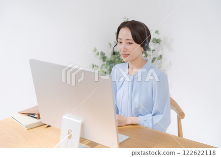Middle-aged woman having an online meeting while teleworking Middle-aged woman having an online meeting while teleworking 122622118