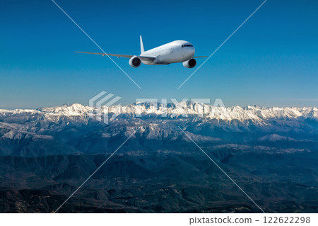 A white wide body aircraft fly over resort mountain town 122622298