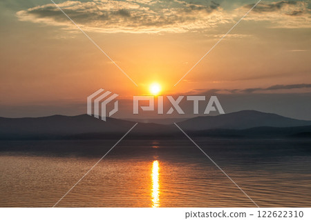 A beautiful lake against the backdrop of a scenic sunrise A beautiful lake against the backdrop of a scenic sunrise 122622310