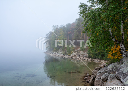 Fog on the rocky shore of a picturesque lake in autumn Fog on the rocky shore of a picturesque lake in autumn 122622312