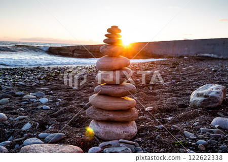Pyramid of pebbles on the seashore at sunset 122622338