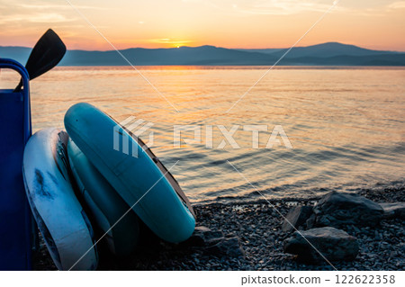 Sup boards on the shore of a picturesque lake against the backdrop of sunrise Sup boards on the shore of a picturesque lake against the backdrop of sunrise 122622358
