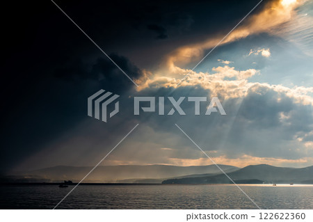 Rays of sun over the lake after heavy rain Rays of sun over the lake after heavy rain 122622360