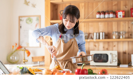 A woman cooking in the kitchen (serving pasta) A woman cooking in the kitchen (serving pasta) 122622405