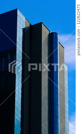 Vertical Modernism - A sleek facade with reflective blue panels and clean geometric lines, perfect for urban design portfolios or architectural branding Vertical Modernism - A sleek facade with reflective blue panels and clean geometric lines, perfect for urban design portfolios or architectural branding 122622473