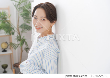 A woman leaning against a wall A woman leaning against a wall 122622599