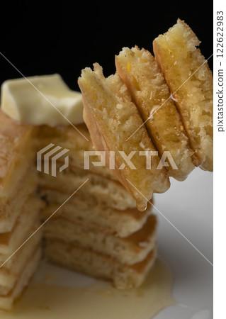 用叉子叉起塗滿蜂蜜的熱餅 用叉子叉起塗滿蜂蜜的熱餅 122622983