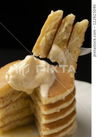 Lifting a hot cake topped with ice cream with a fork Lifting a hot cake topped with ice cream with a fork 122623040