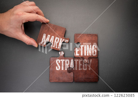 Marketing strategy. Wooden puzzle pieces with text on a dark office table 122623085