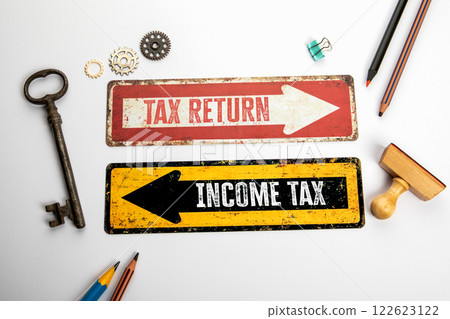 Tax return and Income tax. Red and yellow directional arrow with text Tax return and Income tax. Red and yellow directional arrow with text 122623122