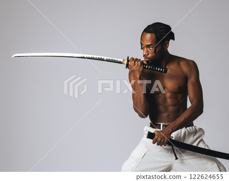 Black man swinging a Japanese sword Black man swinging a Japanese sword 122624655