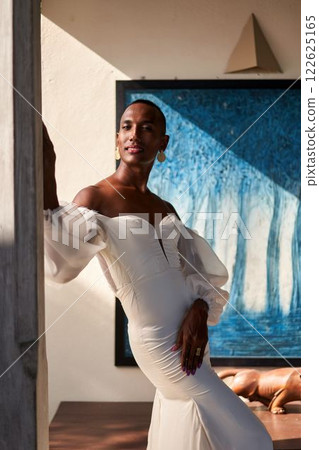 Elegant black person, white bridal dress at villa. Gender fluid, diverse identity. Trendy themes pride, love, self-expression. Ideal for identity, inclusivity storytelling. Luxurious backdrop. 122625165