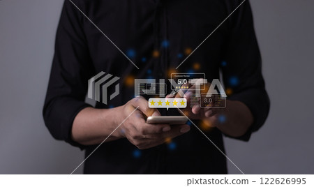 Young Man hand holding Smart Phone with five star to review and give 5 stars Young Man hand holding Smart Phone with five star to review and give 5 stars 122626995