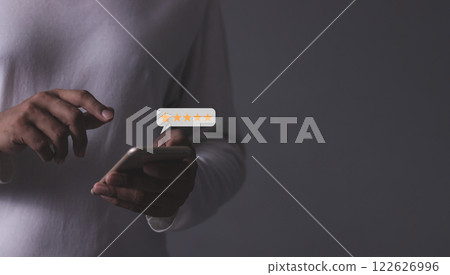 Young Man hand holding Smart Phone with five star to review and give 5 stars Young Man hand holding Smart Phone with five star to review and give 5 stars 122626996