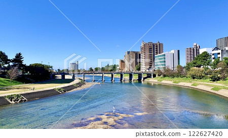 The streetscape around Tonobashi Bridge shining against the clear blue autumn sky (from Sakurajo Bridge over the Otsu River, Okazaki City, Aichi Prefecture) 122627420