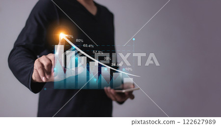 Young man with smartphone mobile hand hold a pen touching to visualize money growth Young man with smartphone mobile hand hold a pen touching to visualize money growth 122627989
