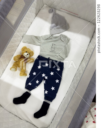 Baby Outfit with Teddy Bear in Crib 122628298