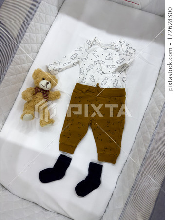 Baby Outfit with Teddy Bear in Crib 122628300