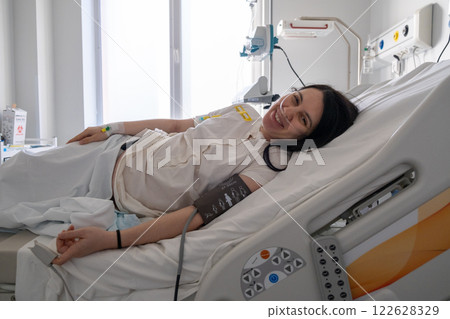Smiling Woman in Hospital Bed with Blood Pressure Cuff Smiling Woman in Hospital Bed with Blood Pressure Cuff 122628329